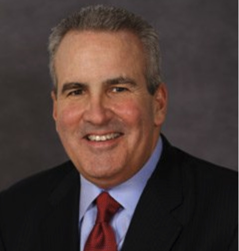 This is a photo of blog author, Bob Happy wearing a black suit with a blue shirt and red tie. 