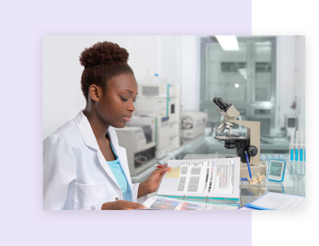 A woman in a medical lab looking through a booklet of documents